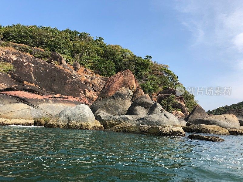 在印度果阿的Palolem蝴蝶海滩的图片，渔船/海豚游轮到达，热带植物，岩石和棕榈树的照片，柔软的金色沙子，温暖的海和附近的蜜月海滩